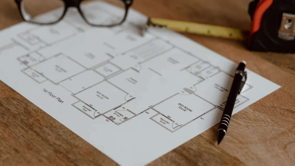 Villa projesi üzerinde çalışan mimar ve plan çizimleri